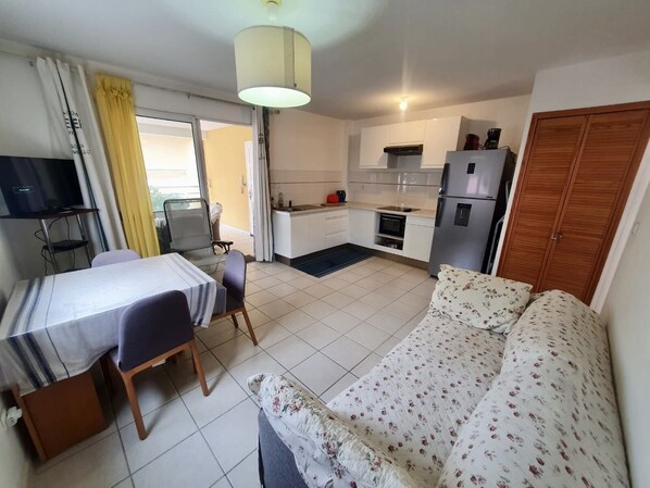A compact living space with a kitchenette, a dining area, and a sofa. - Waterfront T2 apartment (Les Trois-Îlets)