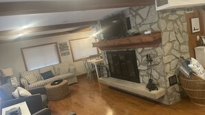 A cozy living room with a stone fireplace, a sofa, and a television. - Waterfront - Near Ark Encounter (Sparta)