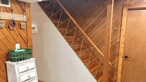 A room with a sloped ceiling, wooden beams, a white dresser, and a door. - Waterfront - Near Ark Encounter (Sparta)