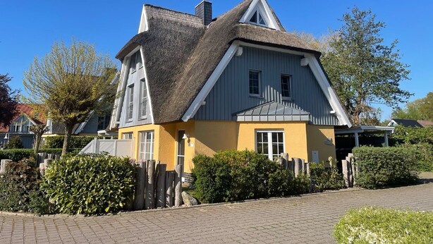 A traditional house with a steep gable roof, a thatched roof section, and a yellow facade. - Mine Heimat 15 "Dat Röverhus" - bright, friendly semi-detached house (Zingst)