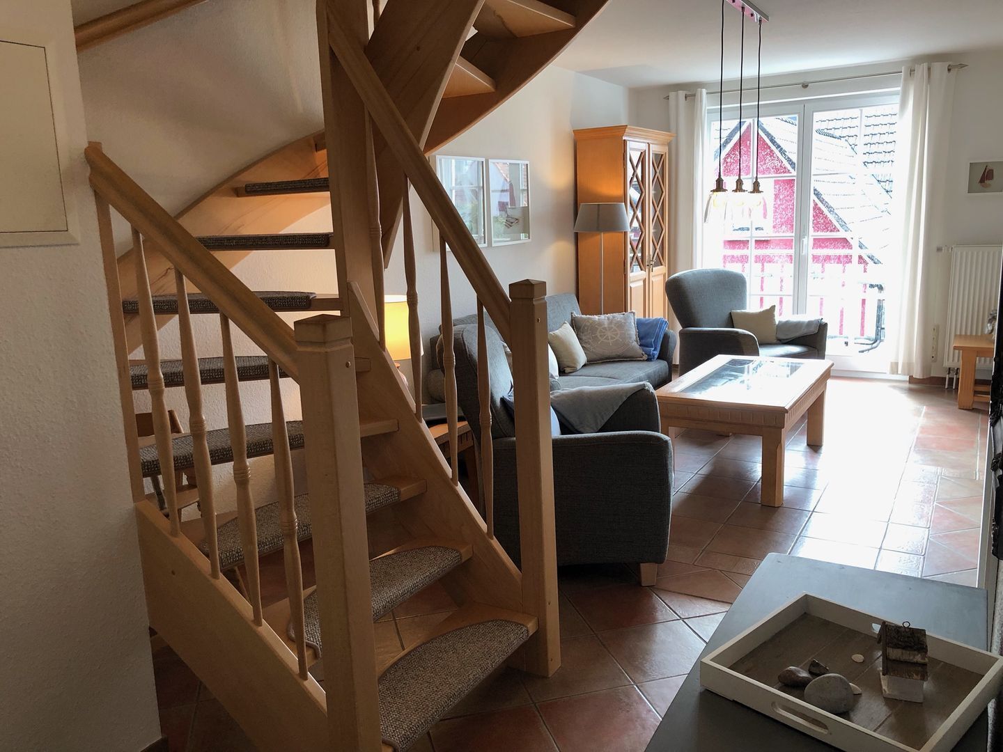 A staircase leading to a living area with a sofa, armchair, and a table.