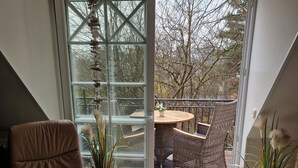 A modern living room with a large sliding glass door leading to an outdoor deck. - Friedenstrasse 20b Whg. 9 "Haus Davide Classique" - exclusive and modern (Zingst)