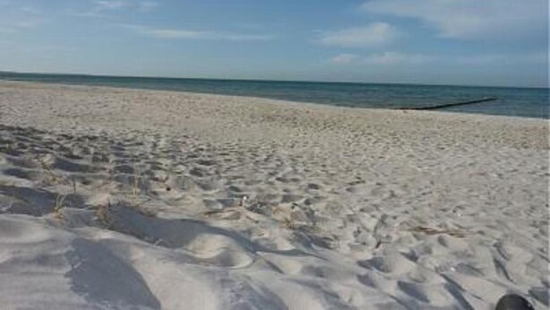 Una spiaggia sabbiosa con cielo sereno.