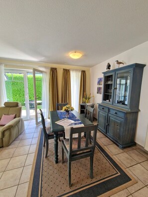 A dining area with a table, chairs, and a cabinet.