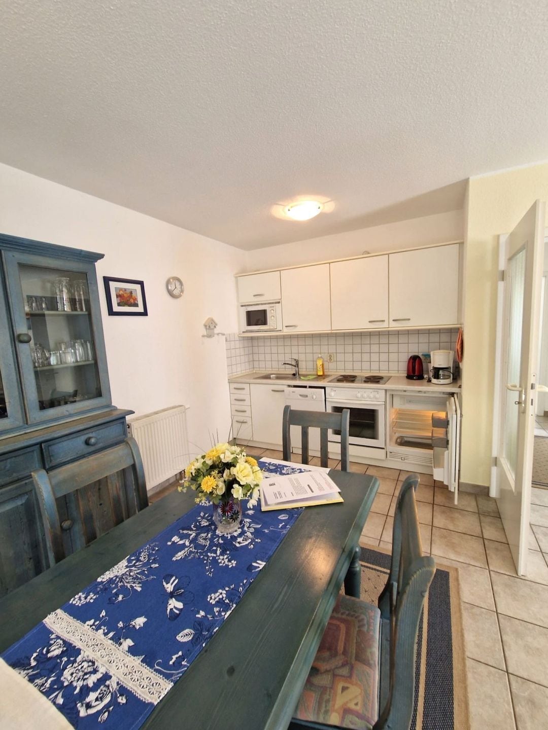 A compact kitchen with white cabinets, a microwave, and a coffee maker.