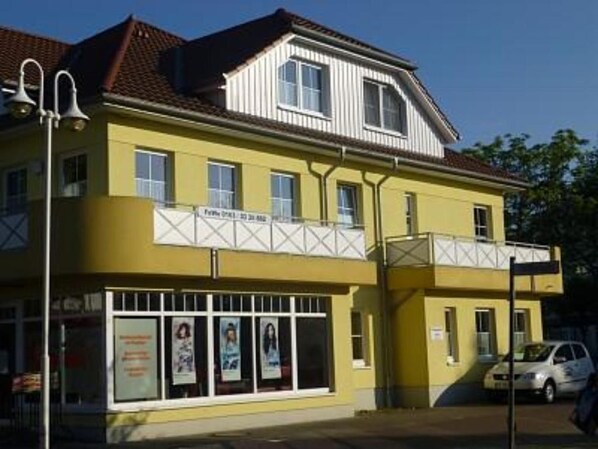 A two-story building with a yellow facade and a balcony. - Hafenstrasse 28, Apt. 3—a beautifully furnished, sun-drenched 3-room apartment (Zingst)