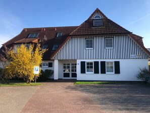 Ein zweistöckiges Gebäude mit einem steilen Dach, weißer Fassade und schwarzen Fensterläden, mit der deutlich sichtbaren Hausnummer 35.
