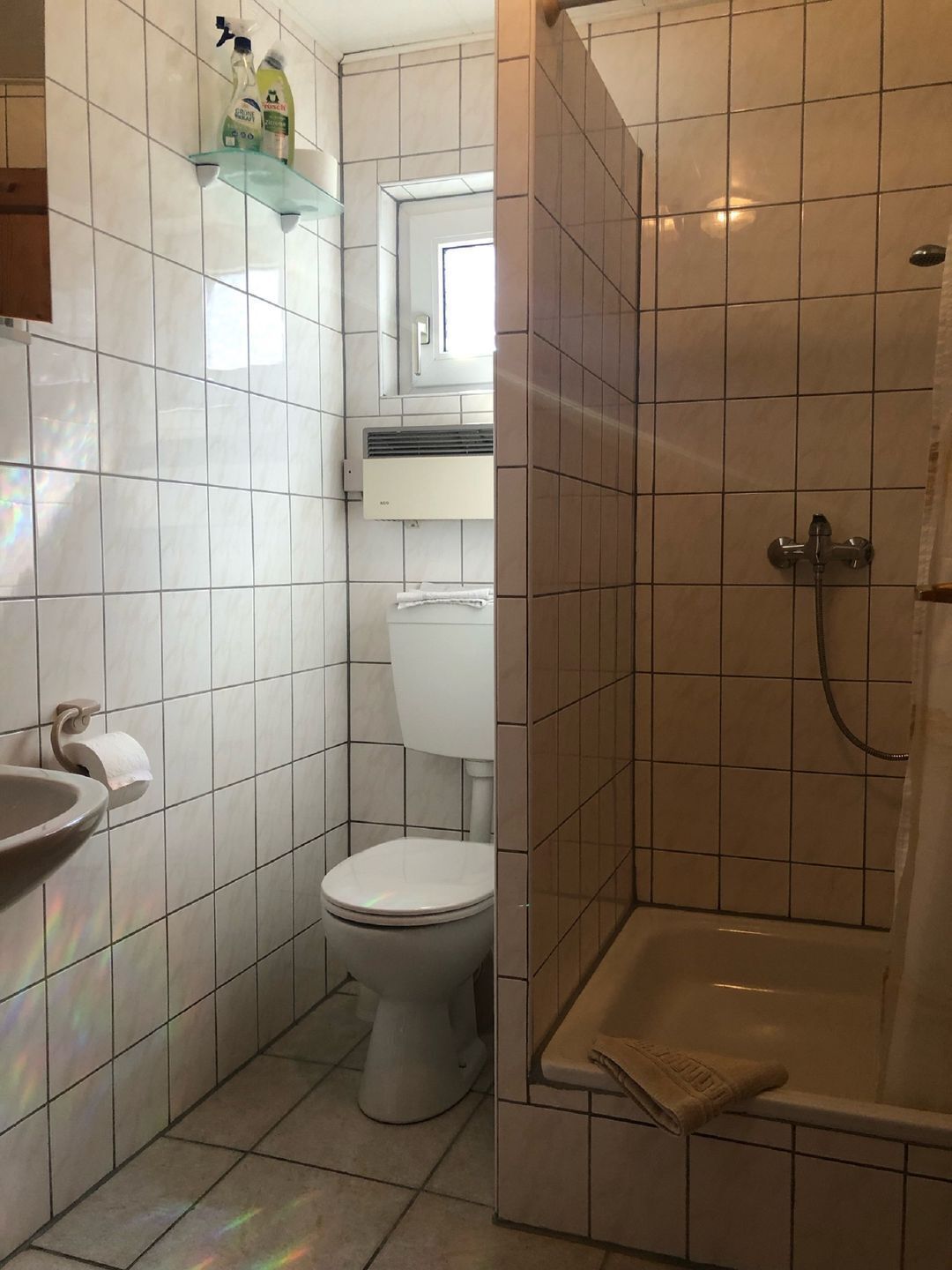 A bathroom with a toilet, sink, and shower.