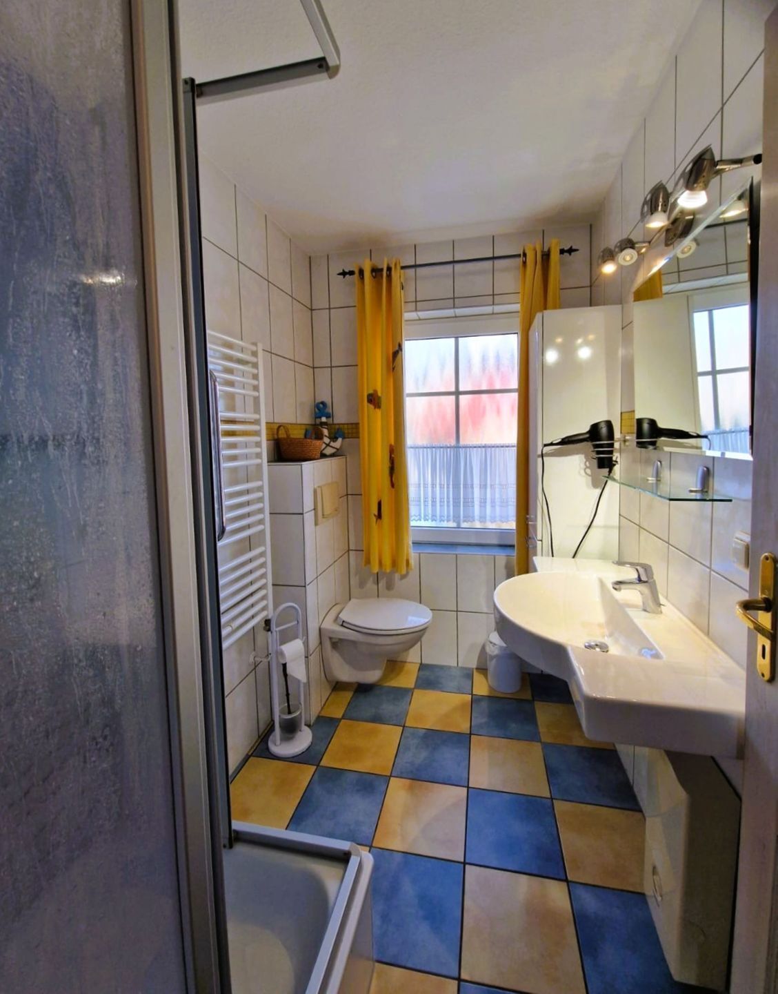 Ein Badezimmer mit Toilette, Waschbecken und Duschbereich.