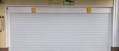 Une porte de garage fermée, avec un panneau au-dessus indiquant la hauteur maximale autorisée pour les véhicules.