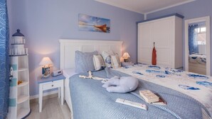 Una camera da letto con un letto, un comodino, una lampada e un armadio.
