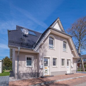 A two-story house with a satellite dish, a front porch, and a mailbox.