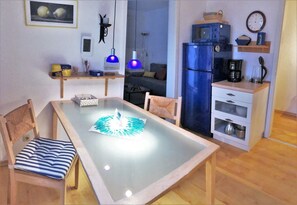 A compact living space with a dining table, chairs, a refrigerator, a microwave, and a coffee maker. - Klosterstrasse 14 Whg. 3 - Modern, comfortable 2-room vacation apartment in the residential (Zingst)