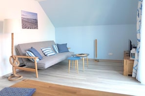 Un salon confortable avec un canapé, une petite table et une lampe.