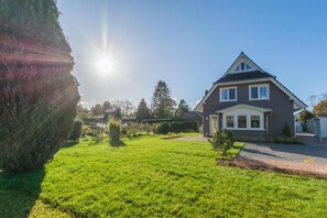 Une maison à deux étages avec une pelouse bien entretenue et un ciel dégagé.