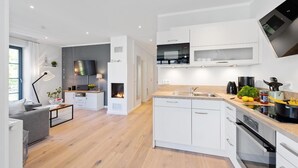 Una cucina moderna con mobili bianchi, forno integrato e microonde.