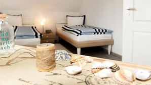 Ein Schlafzimmer mit zwei Betten, einem Nachttisch, einer Lampe und einer Wasserflasche.