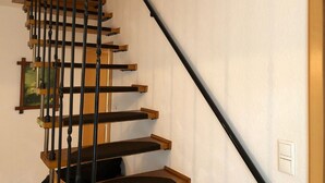Un escalier avec des marches en bois et des balustrades noires.