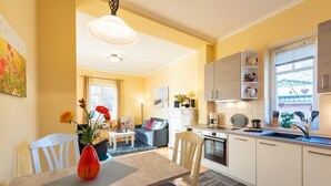 A modern apartment with a dining area, kitchen, and living room. - Neue Reihe 22 Whg. 1 "Villa Balticum" - Modern vacation apartment close to the center (Zingst)