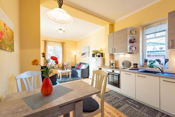 A modern apartment with a dining area, kitchen, and living room.