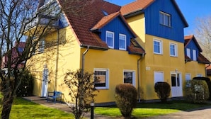 A two-story building with a red roof and yellow and blue exterior walls.