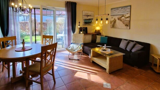 A living room with a dining table, chairs, a sofa, and a coffee table.
