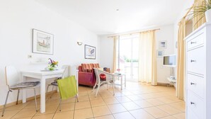 A bright, spacious living area with a dining table, chairs, a sofa, and a TV. - Strandstrasse 51 Whg. 2 - simple vacation apartment including Netflix (Zingst)