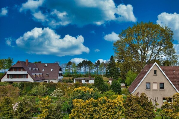 Ein Wohngebiet mit mehreren Häusern, darunter ein zweistöckiges Haus mit Satteldach und ein kleineres Haus mit Giebeldach.