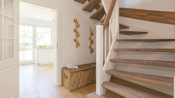 A staircase with wooden steps and a white railing, leading to a room with a white door and a window. - Haseneck 2a " Kranichfeld" - central and yet quietly situated vacation home for (Zingst)