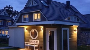 A two-story house with a porch, a bench, and a circular window. - Haseneck 2a " Kranichfeld" - central and yet quietly situated vacation home for (Zingst)