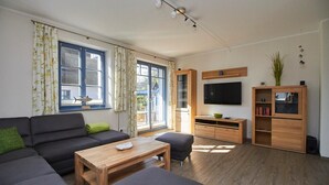 Un salon moderne avec un canapé, une table basse et un meuble pour la télévision.
