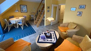 Una sala de estar acogedora con comedor, una escalera y vistas al exterior.
