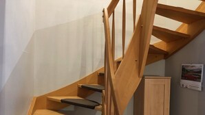 Una scala in legno con corrimano in legno e una porta sul fondo.