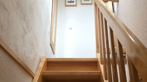A wooden staircase with a handrail leading to a landing.