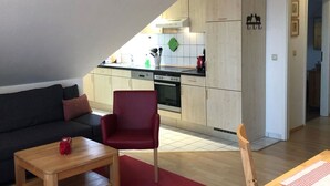 A compact living space with a kitchenette, a dining area, and a seating area.