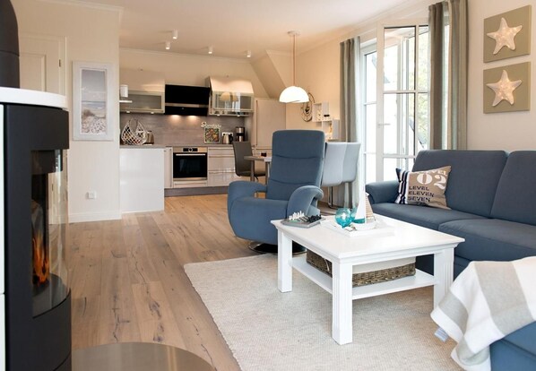 A modern living room with a sofa, a coffee table, and a fireplace.