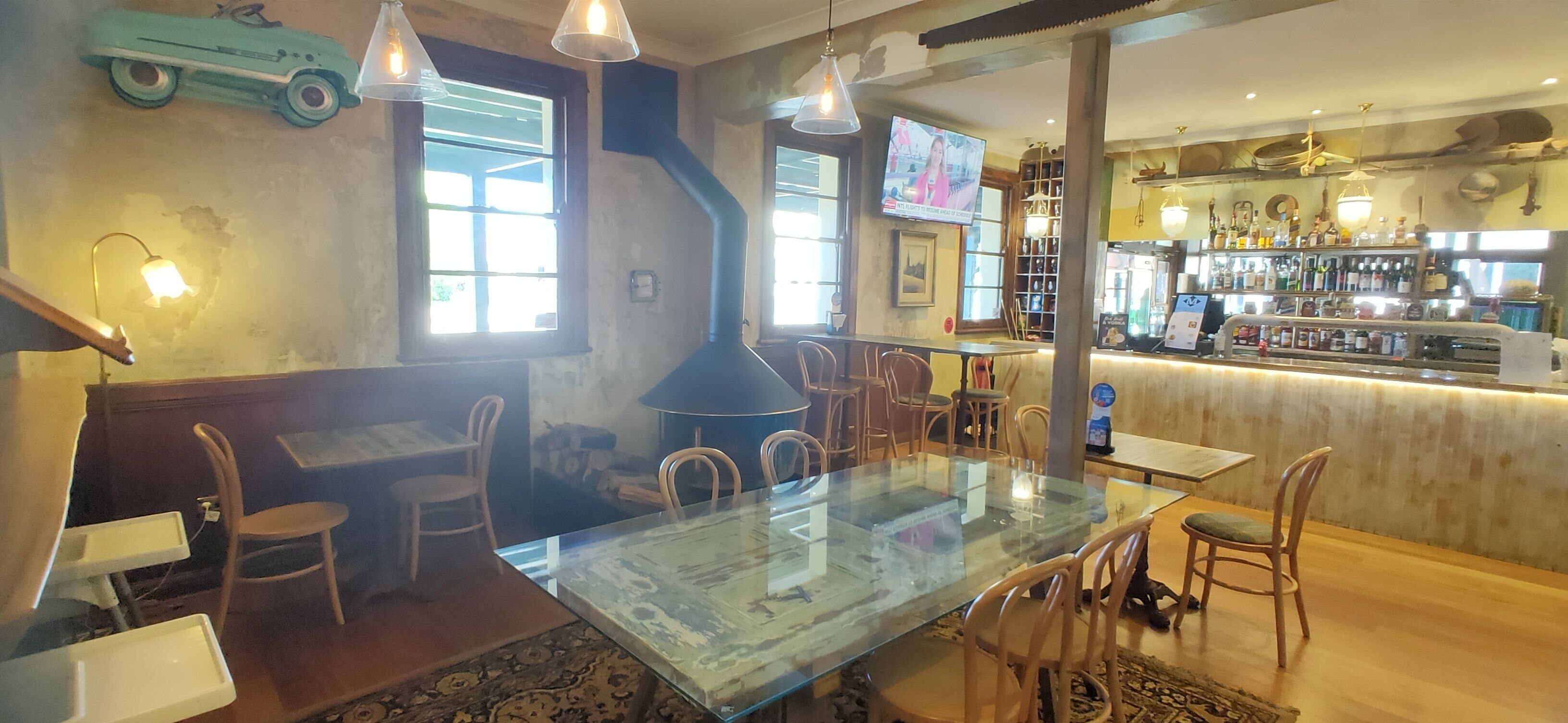 Un espace bar doté d’un long comptoir, de nombreuses chaises et d’un écran de télévision.
