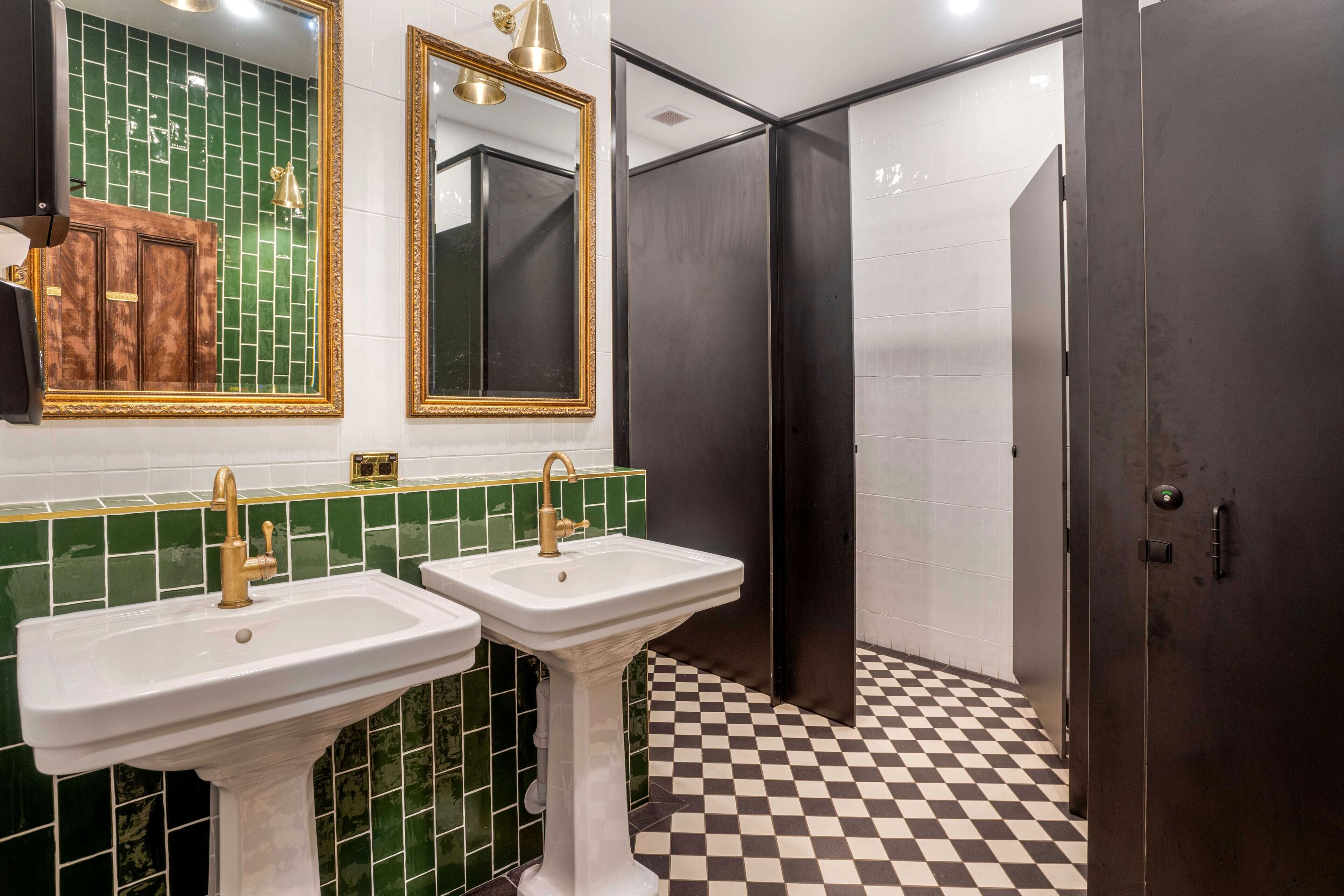 A bathroom with two sinks, a mirror, and a door.