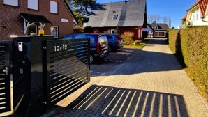 Asuinkatu, jossa on taloja, portti ja parkkeerattuja autoja.