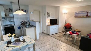 Kompakti oleskelutila, jossa on keittiö, ruokailualue ja pieni oleskelualue.
