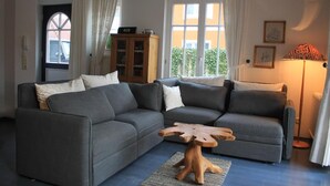A living room with a grey sectional sofa, a wooden coffee table, and a floor lamp.