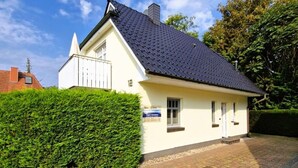 Un bâtiment d’un seul étage, doté d’un toit recouvert de tuiles sombres et d’une façade blanche.