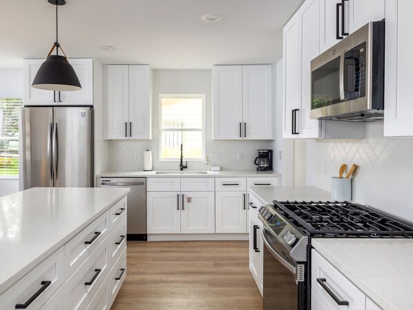 Enjoy cooking and dining in this well-equipped kitchen with a gas stove, refrigerator, microwave, and dishwasher.