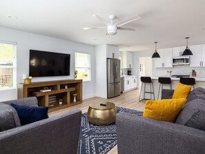 Relax in a spacious living area with a large flat-screen TV, comfortable seating, and a stylish entertainment unit.