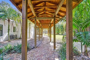 Stroll through the beautifully landscaped grounds, surrounded by lush plants and trees, along a brick pathway.