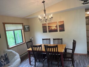 Enjoy meals in this dining area with a table and six chairs, surrounded by artwork and a chandelier.
