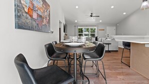 A modern dining area with a round table, black chairs, and a large map artwork on the wall.
