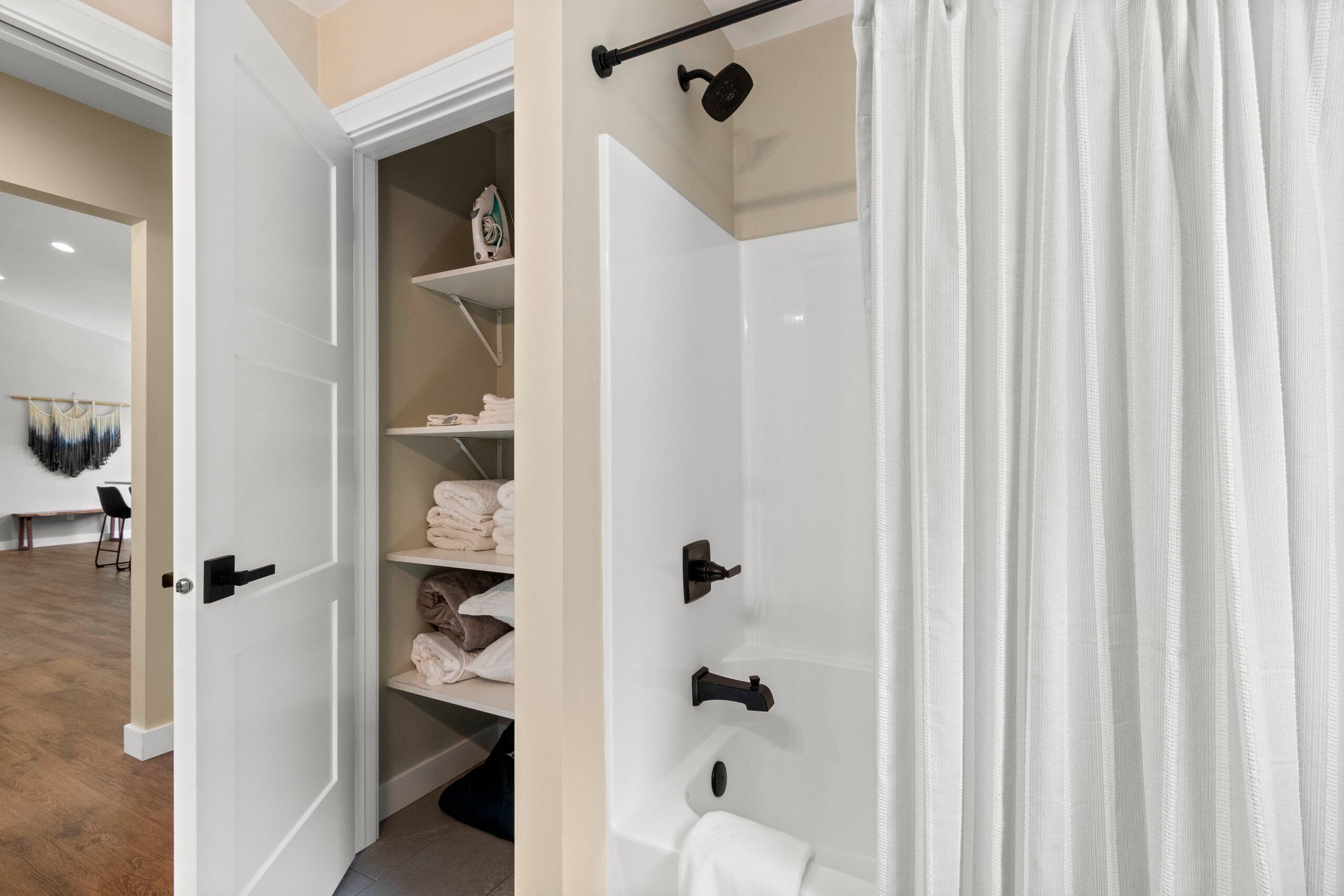 A modern bathroom with a white bathtub, a shower curtain, and a towel rack.