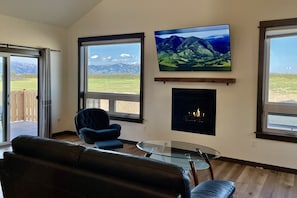 Relax in style with a fireplace, large windows, and a comfortable sofa.