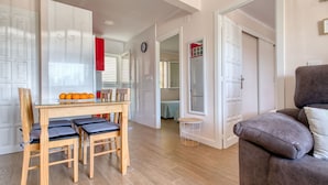 Una sala de estar moderna con una mesa de comedor de madera, un sofá y una pequeña mesa redonda.
